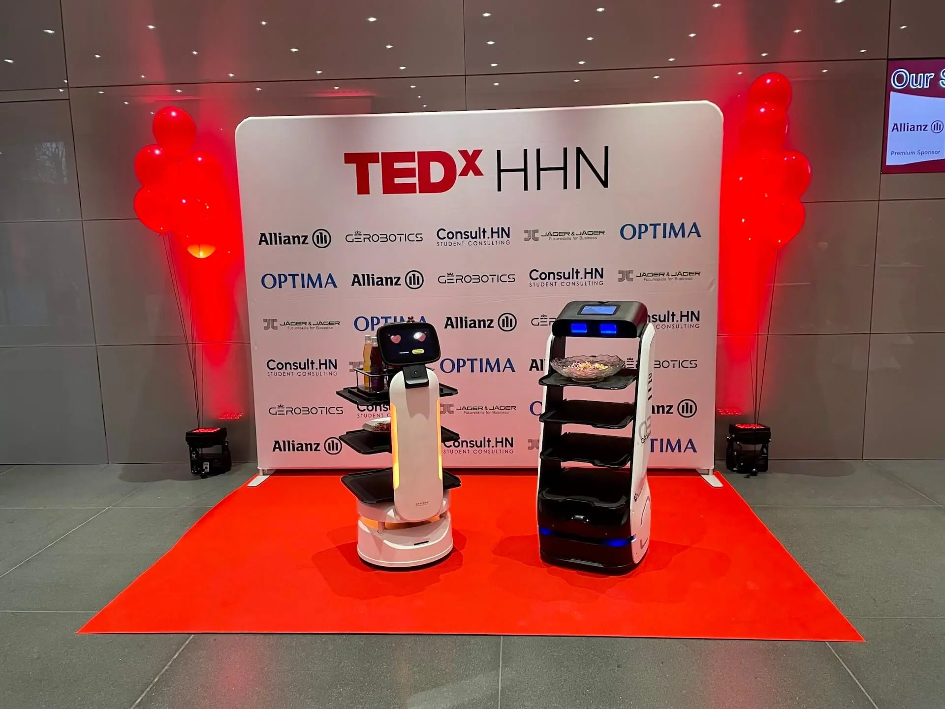 Serviceroboter präsentieren sich auf rotem Teppich bei einer TEDx-Veranstaltung